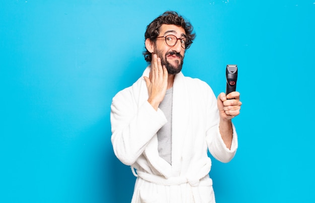 Young bearded man wearing bathrobe. hair or beard care concept