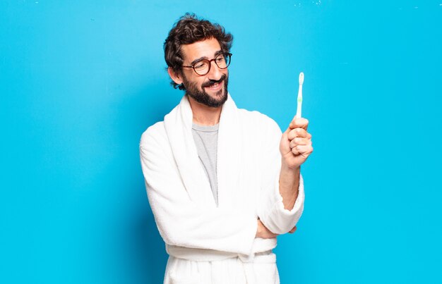 Young bearded man wearing bathrobe and thoothbrush