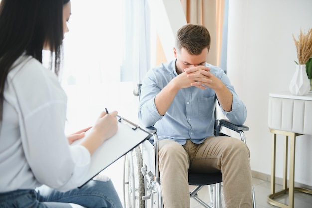 Young bearded man on wheelchair during home psychotherapy