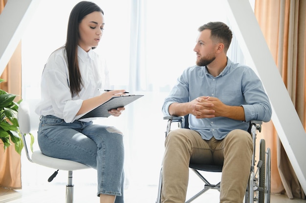 Young bearded man on wheelchair during home psychotherapy