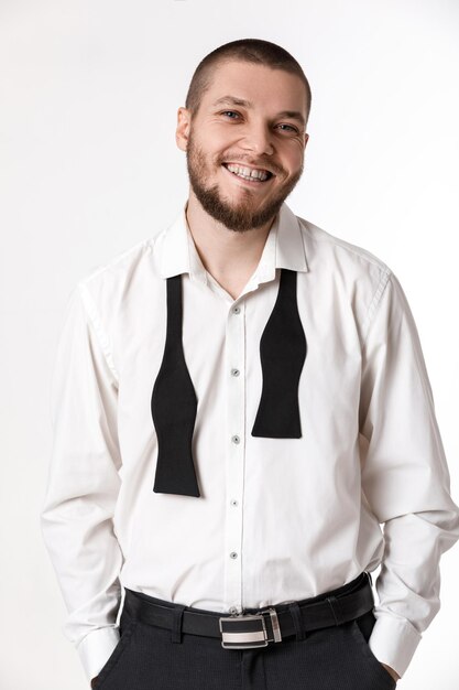 Young bearded man in a white shirt and bow tie