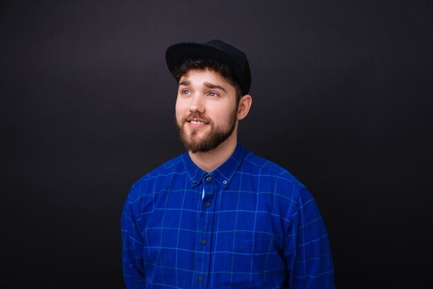 Young bearded man with blue eyes and blue shirt looking in the future dreaming about something.