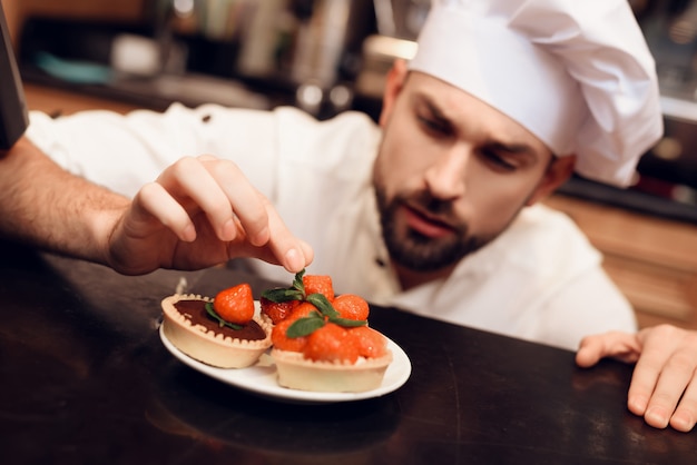 Young Bearded Man with Cake Standing in Bakery