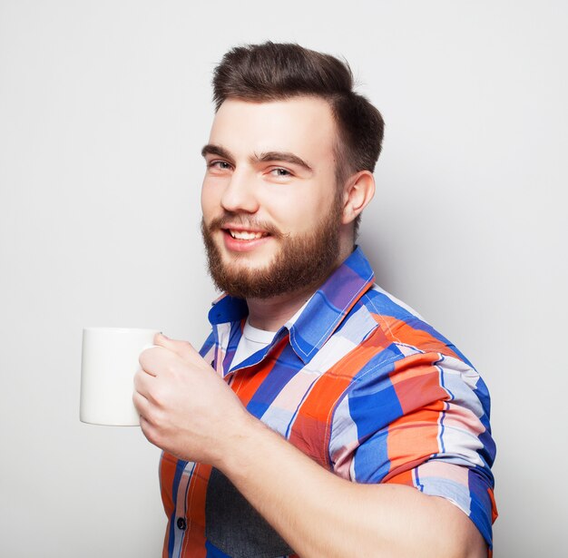 Young bearded man with a cup of coffee