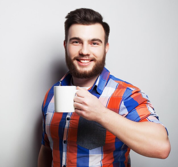 Young bearded man with a cup of coffee