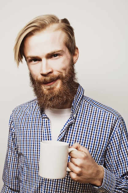 Young bearded man with a cup of coffee