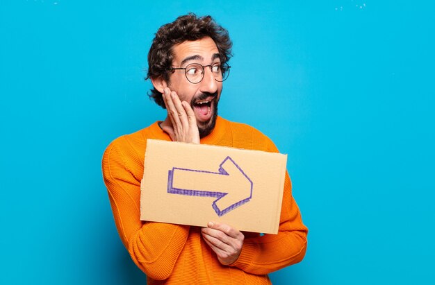 Young bearded man with direction arrow banner