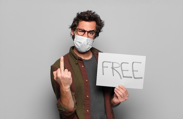 Young bearded man with a medical mask and free banner