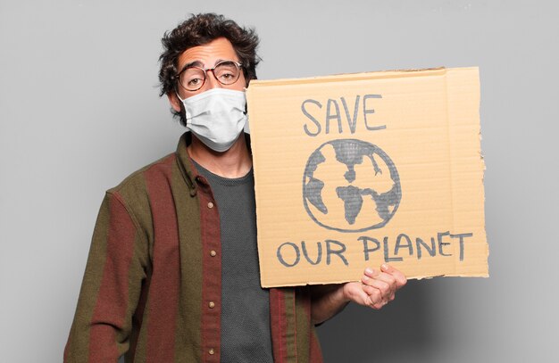 Photo young bearded man with a medical mask. save our planet concept