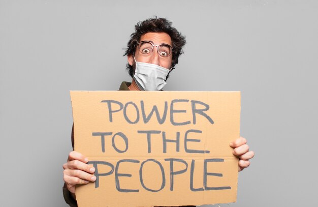 Young bearded man with a medical mask with power to the people concept