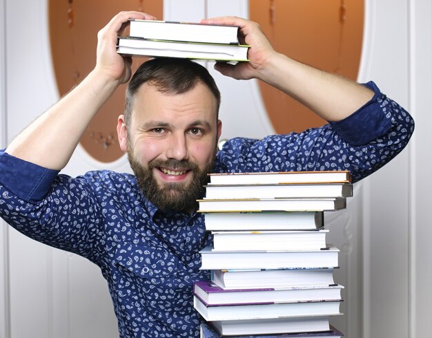 A young bearded man with textbooks for study