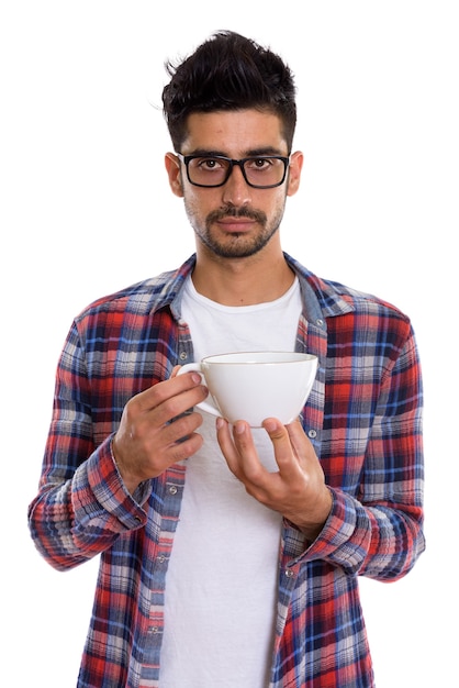 Young bearded Persian hipster man holding coffee cup