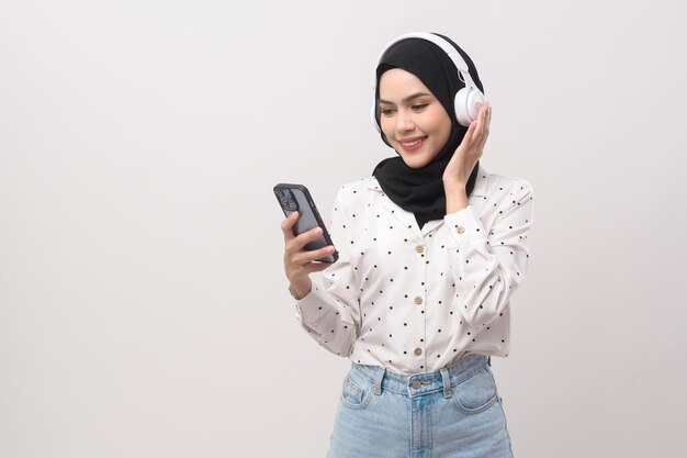 Young beautifu musliml woman wearing headset on white background