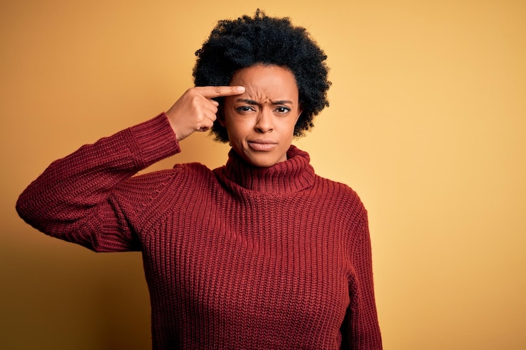 Photo young beautiful african american afro woman with curly hair wearing casual turtleneck sweater pointing unhappy to pimple on forehead ugly infection of blackhead acne and skin problem