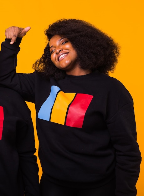 Photo young beautiful african american girl with an afro hairstyle portrait on yellow background