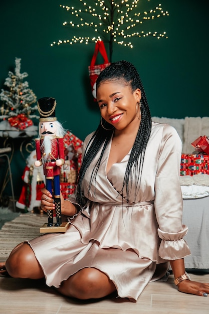 Young beautiful African American woman smiling and playing with Christmas decorations