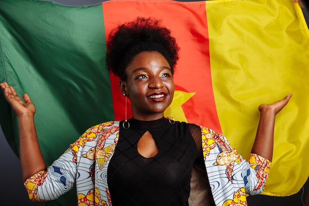 Photo young beautiful african fashion model with flag of cameroon in traditional dress