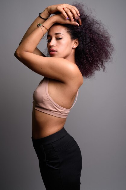 Young beautiful African woman against gray wall