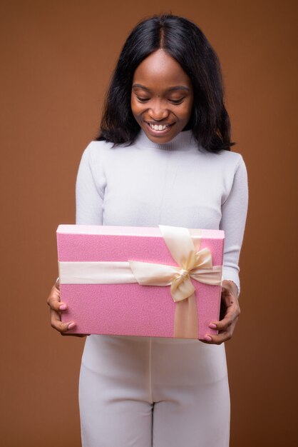 Young beautiful African Zulu businesswoman against brown background