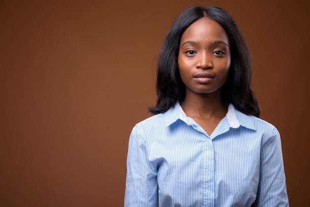 Young beautiful African Zulu businesswoman against brown background