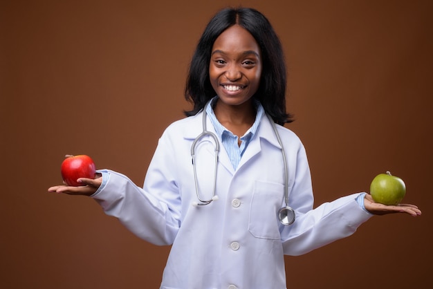 Foto giovane bello medico zulù africano della donna contro backgroundu marrone