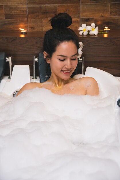 Young beautiful asia woman takes bubble bath