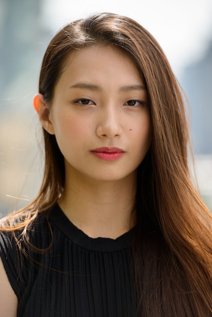 Photo young beautiful asian businesswoman against view of the city