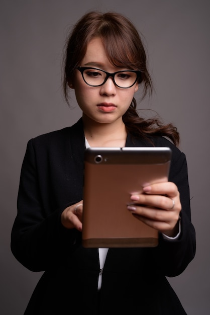 Young beautiful Asian businesswoman using digital tablet