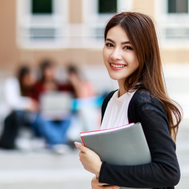 Young and beautiful asian college student girls holding book