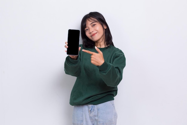 молодая красивая азиатская милая женщина демонстрирует мобильный телефон на белом фоне