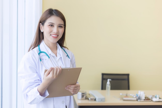 Young beautiful Asian doctor woman working happy and smile in hospital