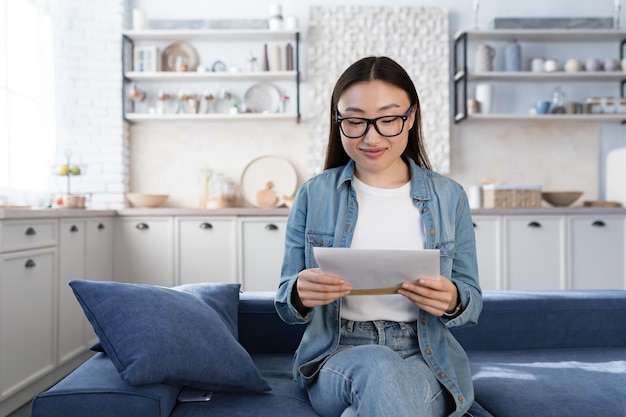 若い美しいアジアの女子学生が受け取った大学の 10 代の少女から幸せな手紙を受け取った