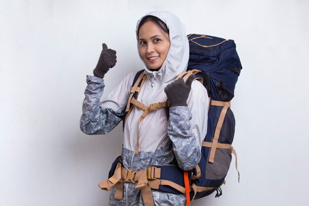 Young beautiful asian hiker woman with backpack showing a thumbs up ok gesture on white background