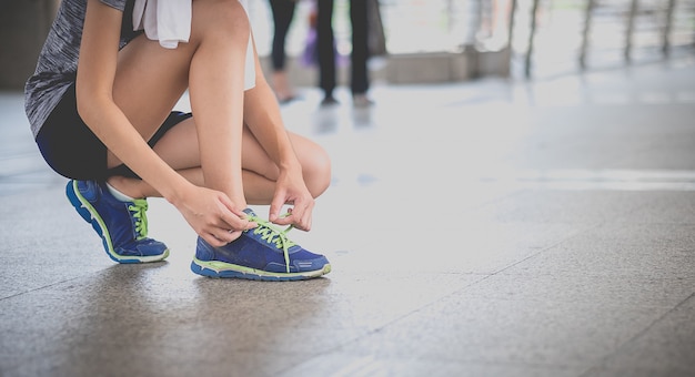 Молодой красивый азиатский модельный jogger женщины бежать в утре сидит