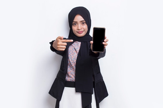 Young beautiful asian muslim woman demonstrating mobile cell phone isolated on white background