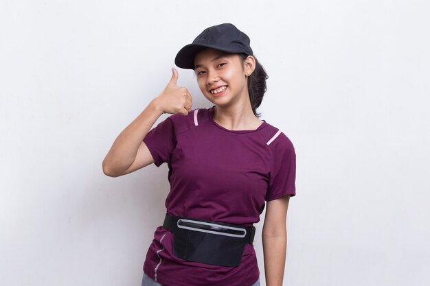 Photo young beautiful asian sporty woman showing a thumbs up ok gesture on white background