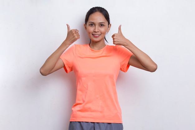 Young beautiful asian sporty woman showing a thumbs up ok gesture on white background