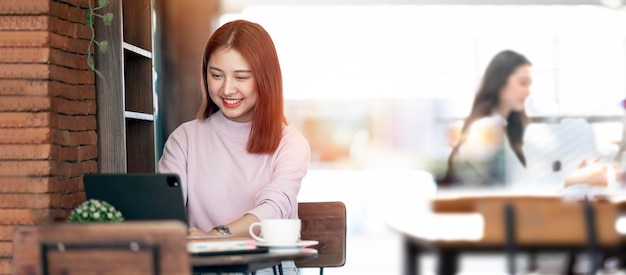 Young beautiful asian student girl using computer working learning in college library