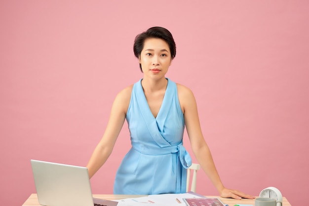 Young beautiful Asian successful businesswoman standing hands on working desk smile at camera