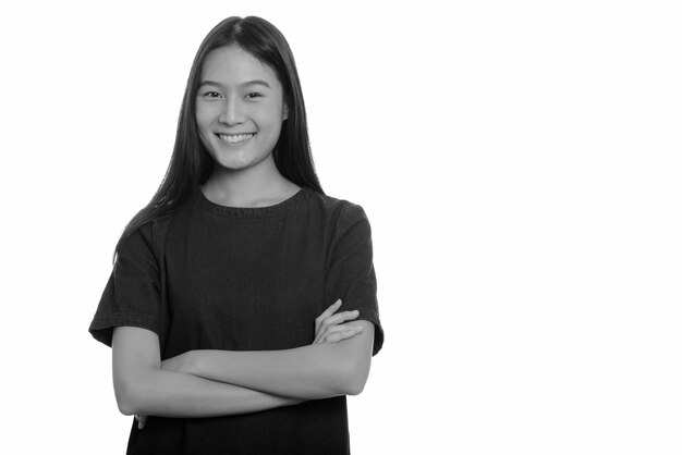  young beautiful Asian teenage girl isolated against white wall in black and white