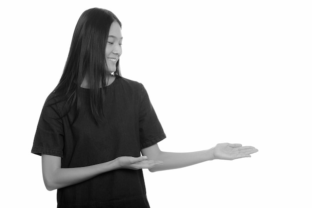  young beautiful Asian teenage girl isolated against white wall in black and white