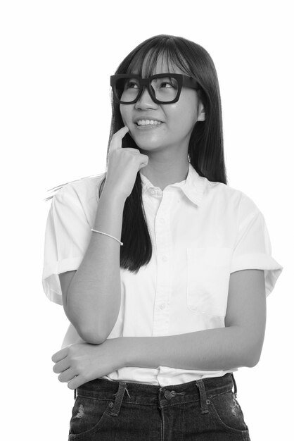 young beautiful Asian teenage girl isolated against white wall in black and white