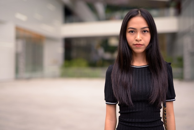 Young beautiful Asian tourist woman at the mall outdoors