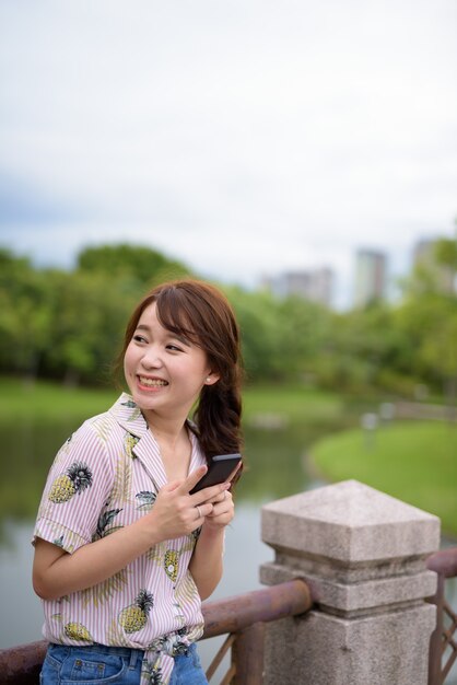 公園でリラックスした若い美しいアジアの観光客の女性