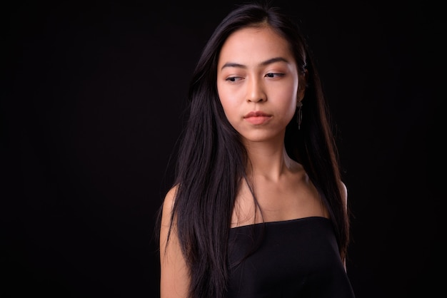 검은 벽에 젊은 아름 다운 아시아 여자