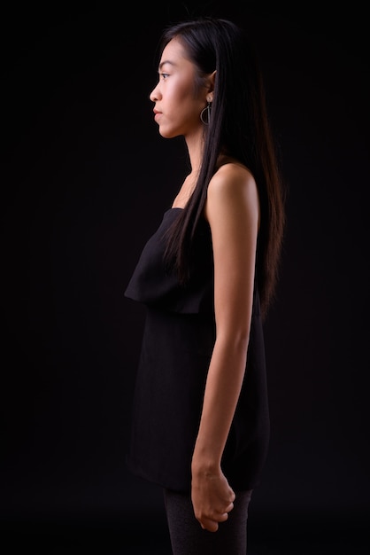молодая красивая азиатская женщина у черной стены