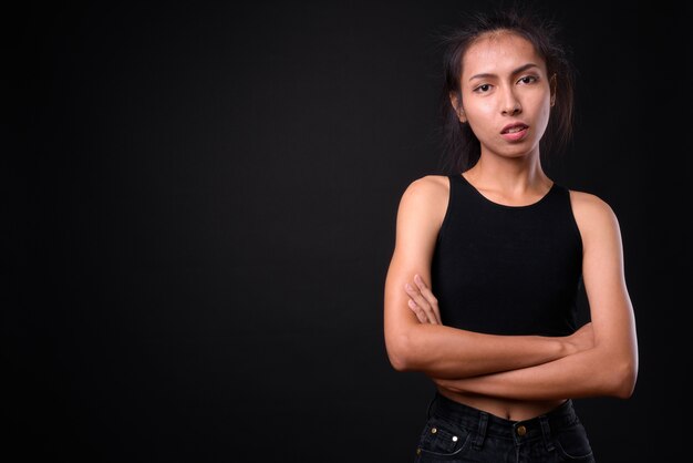  young beautiful Asian  woman against black wall