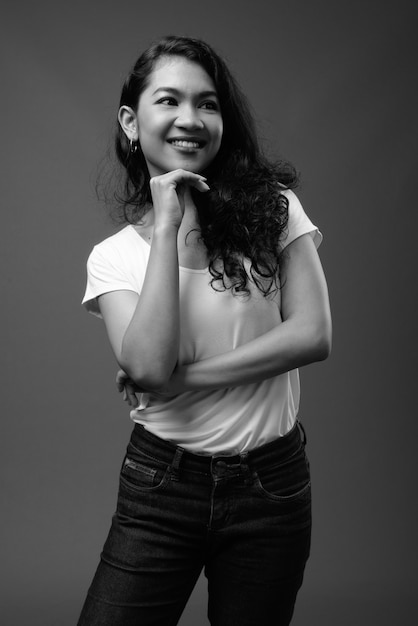  young beautiful Asian woman against gray wall in black and white