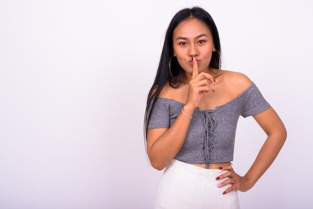  young beautiful Asian woman against white wall