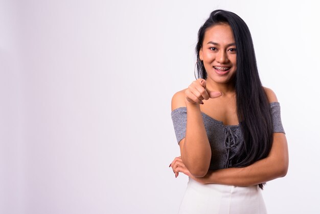  young beautiful Asian woman against white wall